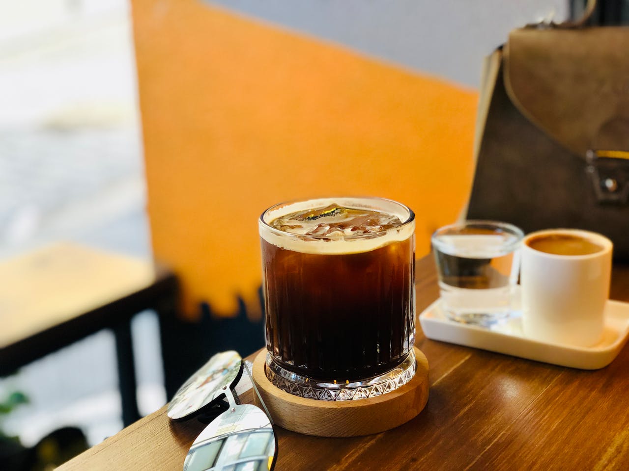 about-us-02 Elegant iced coffee on wooden table with eyeglasses beside, Istanbul café vibe.